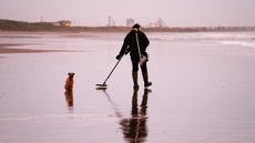 A man seeks treasure on a UK beach