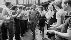 A coal miner is greeted by his wife after a brief occupation of the pit during the miners' strike