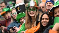 The crowd at 2023's St Patrick's Day parade in Dublin: with Irish tricolour flags and hats, a Guinness hat and shamrock glasses